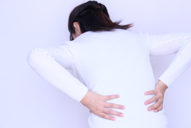 背中の痛みで生活に支障が出て悩む女性